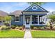Charming blue home featuring a welcoming front porch, manicured landscaping, and classic architectural details at 13034 Royal Fern Dr, Orlando, FL 32828