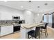 Bright kitchen features stainless steel appliances, white cabinetry, and a granite breakfast bar with pendant lighting at 13034 Royal Fern Dr, Orlando, FL 32828