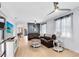 Bright living room with a modern entertainment center, hardwood floors, and comfortable leather seating at 13034 Royal Fern Dr, Orlando, FL 32828
