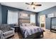 Comfortable main bedroom with accent wall, ceiling fan, and access to the en-suite bath at 13034 Royal Fern Dr, Orlando, FL 32828