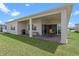View of backyard with covered patio and outdoor dining area with well-manicured lawn at 13133 Sunny Retreat Ln, Winter Garden, FL 34787
