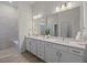 Elegant bathroom with double vanity, white cabinetry, and a large framed mirror at 13133 Sunny Retreat Ln, Winter Garden, FL 34787