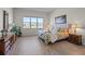 Bright bedroom featuring a large window, wood-look flooring, and stylish furniture at 13133 Sunny Retreat Ln, Winter Garden, FL 34787