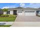 Charming single-story home with a three-car garage, paver driveway, and beautifully landscaped front yard at 13133 Sunny Retreat Ln, Winter Garden, FL 34787