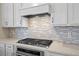 Modern kitchen with stainless steel appliances, custom backsplash, and stylish countertops at 13133 Sunny Retreat Ln, Winter Garden, FL 34787