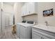 Laundry room featuring modern appliances, white cabinets, and a large utility sink at 13133 Sunny Retreat Ln, Winter Garden, FL 34787
