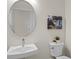 Well lit powder room with a pedestal sink, decorative oval mirror, and modern toilet at 13133 Sunny Retreat Ln, Winter Garden, FL 34787