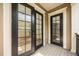 Outdoor porch with black doors and windows, white painted pillars, and a grey deck at 1316 Lake Baldwin Ln, Orlando, FL 32814