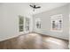 Bright, empty bedroom featuring hardwood floors, two windows, a ceiling fan, and a private balcony at 1316 Lake Baldwin Ln, Orlando, FL 32814