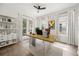 Home office with a modern wood desk, white curtains, a ceiling fan, and a bookshelf at 1316 Lake Baldwin Ln, Orlando, FL 32814