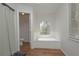 Bright bathroom features a soaking tub under an arched window, plus a shower and toilet in the adjacent room at 14433 Huntingfield Dr, Orlando, FL 32824