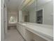 Bathroom with double sink vanity, bright lighting, lots of counterspace, and a view of the tub/shower area at 14433 Huntingfield Dr, Orlando, FL 32824