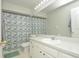 Bright bathroom featuring white vanity and a shower with patterned curtain at 14433 Huntingfield Dr, Orlando, FL 32824
