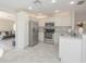 Bright kitchen featuring stainless steel appliances, white cabinetry, and a convenient breakfast bar at 14433 Huntingfield Dr, Orlando, FL 32824