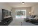 Cozy living room featuring modern entertainment setup and sliding doors to the pool area at 14433 Huntingfield Dr, Orlando, FL 32824