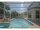 Screened-in pool and spa, deck with room for chairs, view of the house and back yard at 14433 Huntingfield Dr, Orlando, FL 32824