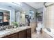Well-lit bathroom with double vanity, granite countertops, tiled floors, and bathtub at 1448 Lambert St, Deltona, FL 32725