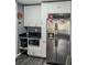 A modern kitchen with stainless steel refrigerator, white cabinets and black countertops at 1448 Lambert St, Deltona, FL 32725
