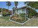 Landscaped yard with vibrant flower beds and a cozy patio area at 1448 Lambert St, Deltona, FL 32725