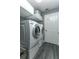 Modern laundry room with updated washer, dryer, shelving and gray wood-look flooring at 1448 Lambert St, Deltona, FL 32725