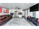 Spacious living room featuring a plush leather sofa and modern decor and kitchen views at 1448 Lambert St, Deltona, FL 32725