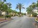 Gated entrance to a condominium community featuring lush landscaping and palm trees at 1475 Lake Shadow Cir # 6205, Maitland, FL 32751