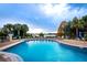 Sparkling community pool with ample lounge chairs and palm trees overlooking the lake at 1475 Lake Shadow Cir # 6205, Maitland, FL 32751