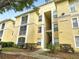 Attractive condo building showcasing its balconies and yellow paint, complemented by lush greenery at 1475 Lake Shadow Cir # 6205, Maitland, FL 32751