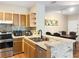 Functional kitchen with stainless steel appliances, wood cabinets, and decorative stone bar area adjacent to the dining space at 1475 Lake Shadow Cir # 6205, Maitland, FL 32751
