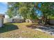 Large, grassy backyard with mature trees and a wooden fence, offering ample space and privacy at 1624 Bel Air Ave, Orlando, FL 32812