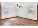 The bright, unfurnished bedroom features hardwood floors and two sun-filled windows at 1624 Bel Air Ave, Orlando, FL 32812