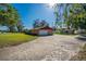 Side view of the home featuring a two-car garage, expansive driveway, and well-maintained lawn at 1624 Bel Air Ave, Orlando, FL 32812
