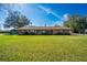 Charming single-story brick home with a well-manicured lawn and mature trees against a bright blue sky at 1624 Bel Air Ave, Orlando, FL 32812