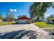View of the detached garage features a wide driveway and a well-manicured lawn at 1624 Bel Air Ave, Orlando, FL 32812