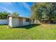 Exterior of detached shed with access door, window and partial view of property's side and back yard at 1624 Bel Air Ave, Orlando, FL 32812