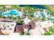 An aerial view of community pools, a splashpad, lounge areas, and beautiful landscaping by a lake at 1644 Tropical Palms Cir, Kissimmee, FL 34747