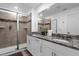 Modern bathroom with a double vanity, granite countertop, and glass-enclosed shower at 1644 Tropical Palms Cir, Kissimmee, FL 34747