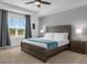 Spacious bedroom with a large window, tray ceiling, and elegant bedside tables at 1644 Tropical Palms Cir, Kissimmee, FL 34747