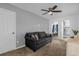 Casual living room with neutral carpet, a gray sofa, and access to other rooms at 1644 Tropical Palms Cir, Kissimmee, FL 34747