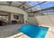 Screened-in pool with paver decking, seating and lush landscaping at 1644 Tropical Palms Cir, Kissimmee, FL 34747