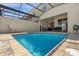 Screened-in pool with paver decking, a lounge chair and lush landscaping at 1644 Tropical Palms Cir, Kissimmee, FL 34747