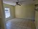 Bedroom with tile flooring and ceiling fan, featuring a bright window and side shelves at 2018 Knollcrest Dr, Clermont, FL 34711