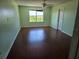 Bright bedroom features wood-look floors, a ceiling fan, and a large window with a scenic view at 2018 Knollcrest Dr, Clermont, FL 34711