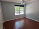 Cozy bedroom featuring wood-look floors, ceiling fan, and a bright window at 2018 Knollcrest Dr, Clermont, FL 34711