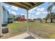 Spacious backyard featuring a playground, green grass, and partially covered porch at 2028 Royal Bay Blvd # 85, Kissimmee, FL 34746