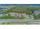 A wide aerial view of apartment homes, a community tennis court, trees, a pond, and highway at 2047 Royal Bay Blvd # 21, Kissimmee, FL 34746