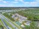 A wide aerial view of apartment homes with a community pool, a playground, tennis court, and highway at 2047 Royal Bay Blvd # 21, Kissimmee, FL 34746
