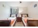 Bright bedroom with two twin beds, a ceiling fan, and a window with tree view at 2047 Royal Bay Blvd # 21, Kissimmee, FL 34746