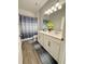 Well-lit bathroom featuring a double vanity, a shower/tub combination, and wood-look tile flooring at 2445 Verde View Dr, Apopka, FL 32703