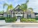 Attractive clubhouse entrance featuring stone accents, palm trees, and manicured landscaping at 2445 Verde View Dr, Apopka, FL 32703